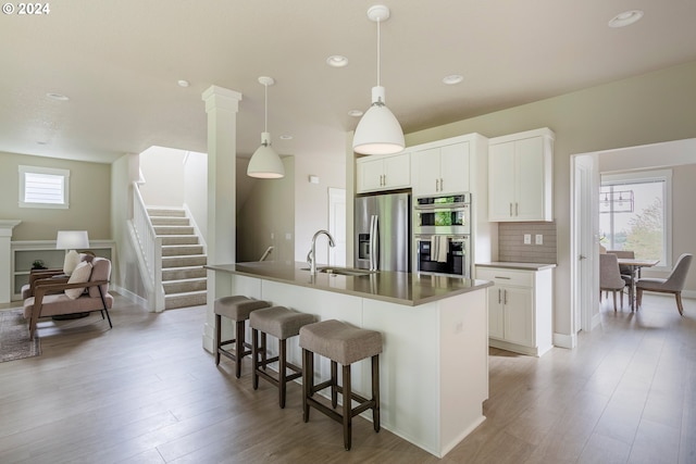 kitchen featuring a center island with sink, appliances with stainless steel finishes, a healthy amount of sunlight, and sink