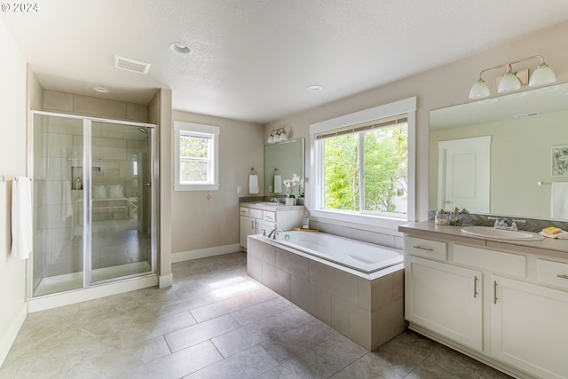 bathroom featuring tile patterned flooring, a textured ceiling, independent shower and bath, and vanity