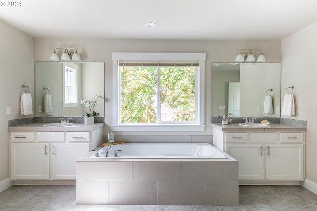 bathroom featuring tile patterned floors, tiled bath, and vanity