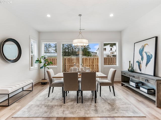 dining room featuring a wealth of natural light, a notable chandelier, and light wood-type flooring