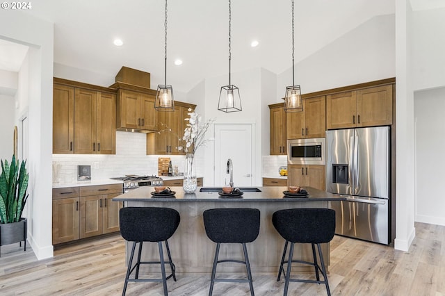 kitchen with appliances with stainless steel finishes, a kitchen breakfast bar, sink, a center island, and lofted ceiling