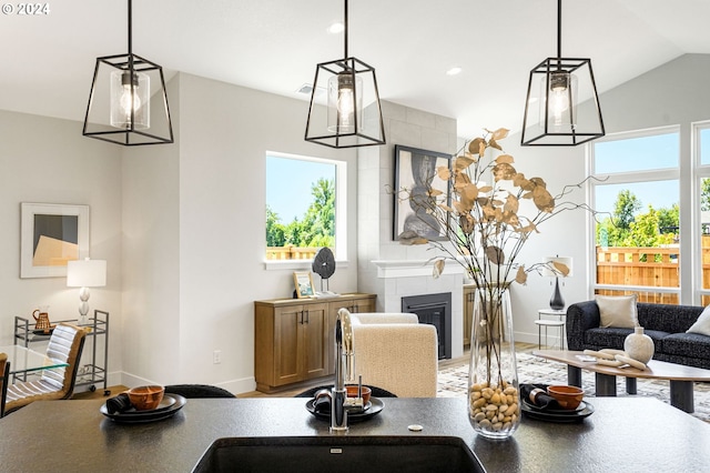 interior space featuring sink, lofted ceiling, and a tiled fireplace