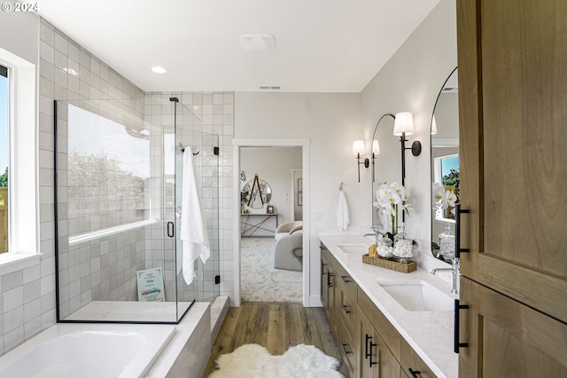 bathroom featuring plus walk in shower, vanity, hardwood / wood-style flooring, and plenty of natural light