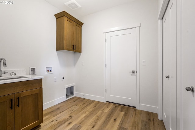 laundry area with sink, cabinets, washer hookup, hookup for an electric dryer, and light hardwood / wood-style flooring