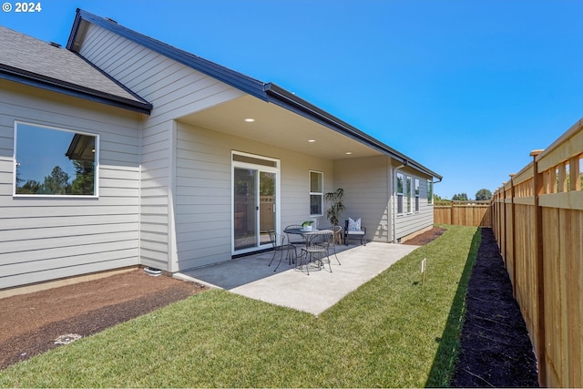 back of property with a patio and a lawn