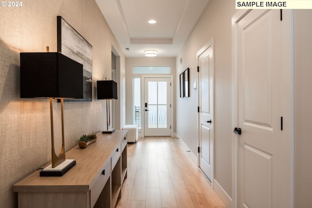 mudroom featuring light hardwood / wood-style floors and a tray ceiling