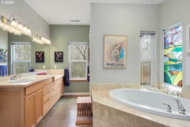 bathroom with tile flooring, tiled bath, and vanity