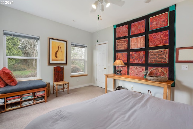 carpeted bedroom featuring ceiling fan and a closet