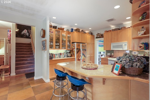 kitchen with white appliances, a breakfast bar, light tile floors, tile countertops, and tasteful backsplash