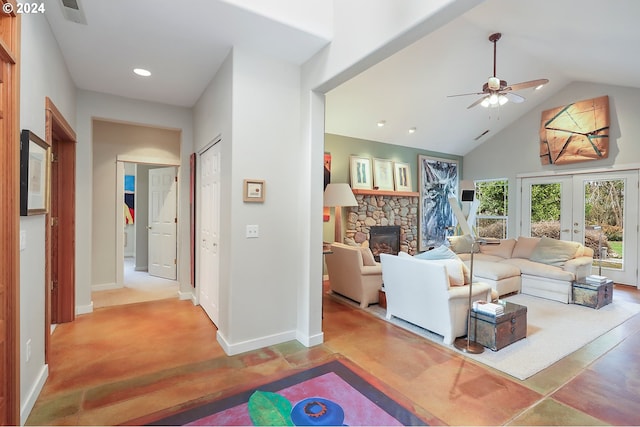 carpeted living room featuring french doors, ceiling fan, a stone fireplace, and lofted ceiling