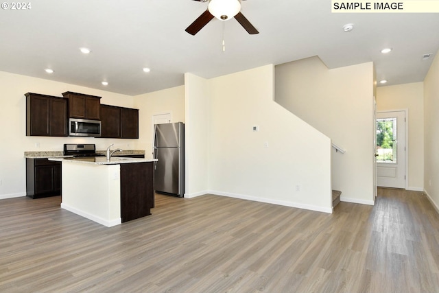 3915 SW Duniway Ln, Gresham, OR 97080 - kitchen featuring appliances with stainless steel finishes, light wood-style flooring, open floor plan, a ceiling fan, and dark brown cabinetry