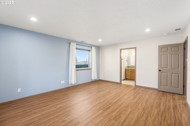 interior space with light hardwood / wood-style floors and connected bathroom