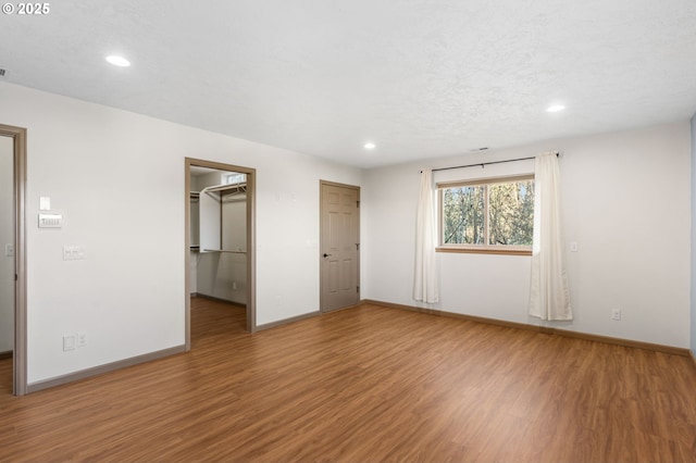 spare room with a textured ceiling and hardwood / wood-style flooring