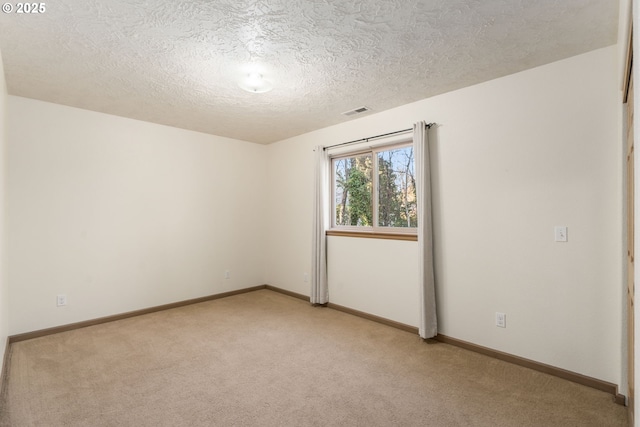 carpeted spare room featuring a textured ceiling