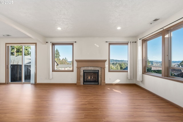 unfurnished living room with hardwood / wood-style floors and a textured ceiling