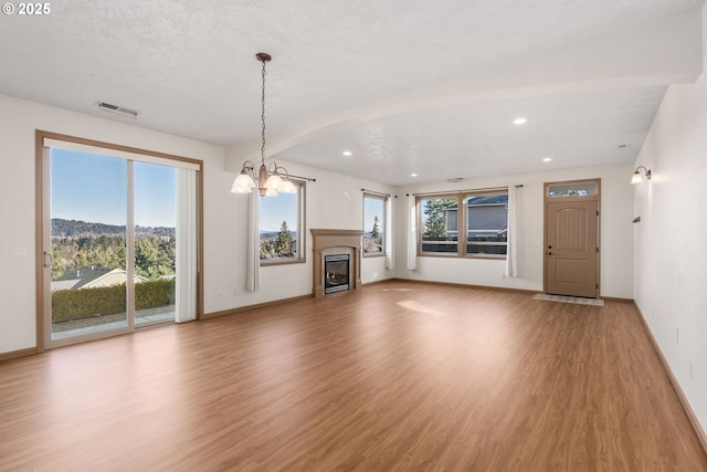 unfurnished living room with hardwood / wood-style flooring and an inviting chandelier