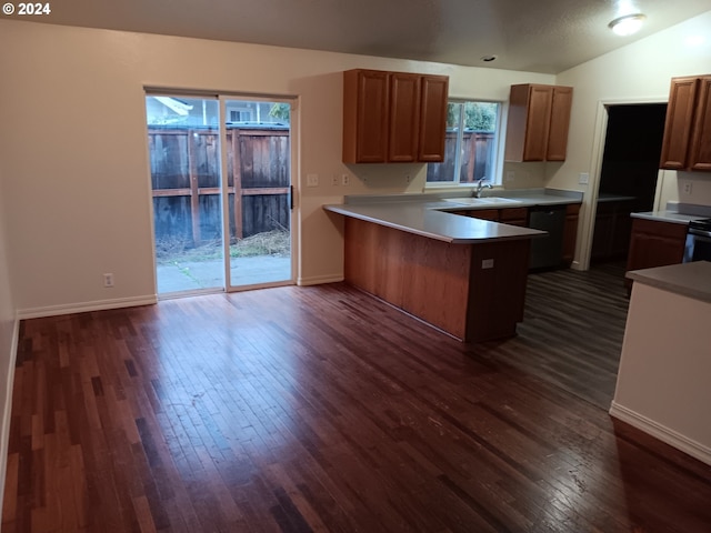 kitchen featuring lofted ceiling, a kitchen breakfast bar, sink, dark hardwood / wood-style floors, and kitchen peninsula