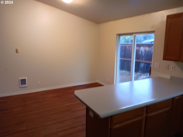 kitchen featuring kitchen peninsula and dark hardwood / wood-style flooring