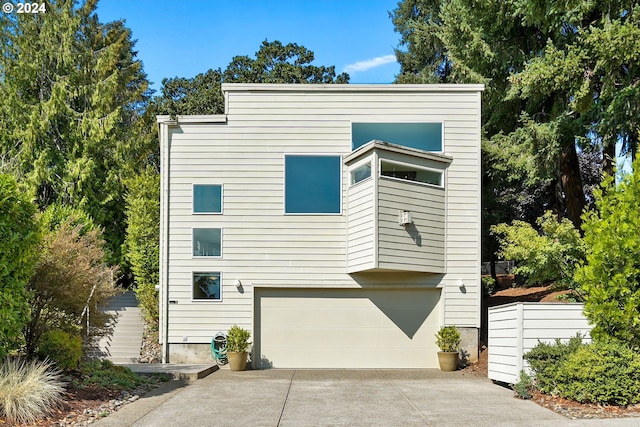 view of property exterior featuring an attached garage and concrete driveway