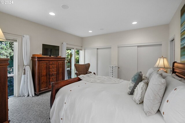 bedroom featuring recessed lighting, two closets, and light colored carpet