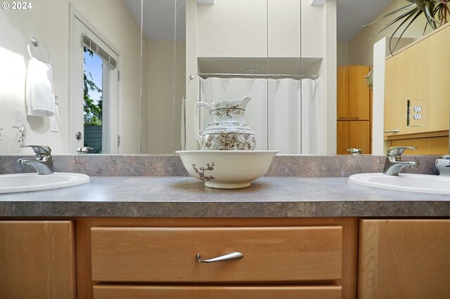 bathroom featuring double vanity, a shower with curtain, and a sink