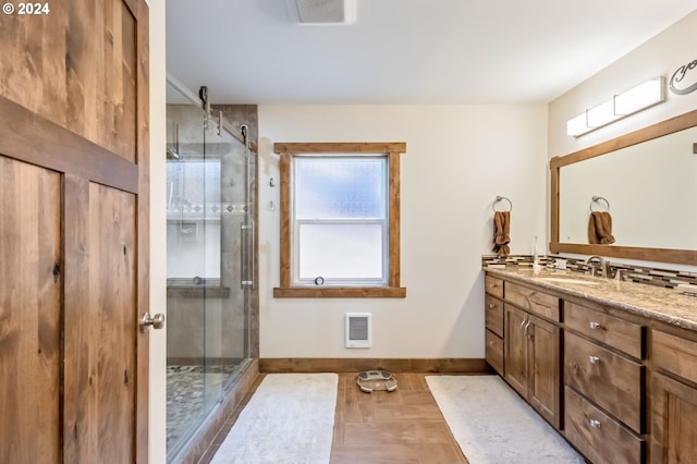 bathroom featuring heating unit, walk in shower, and vanity