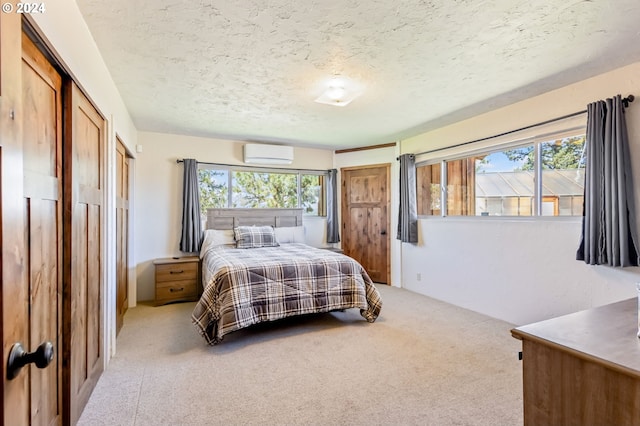 carpeted bedroom featuring a textured ceiling and a wall mounted AC