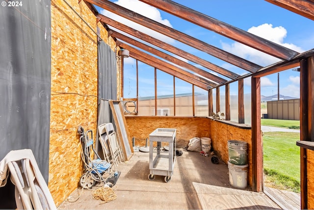 unfurnished sunroom with lofted ceiling with beams