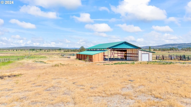 view of outdoor structure featuring a mountain view and a rural view