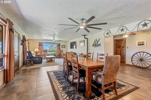 tiled dining room with ceiling fan and a textured ceiling