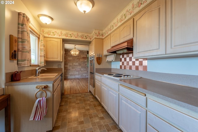 kitchen featuring pendant lighting, sink, premium range hood, multiple ovens, and white electric cooktop