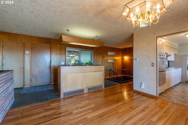 kitchen with wooden walls, light wood-type flooring, and double oven