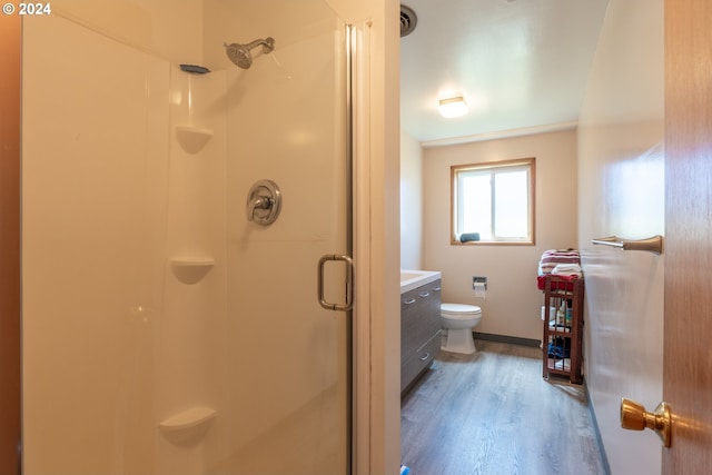 bathroom with crown molding, an enclosed shower, toilet, vanity, and hardwood / wood-style floors