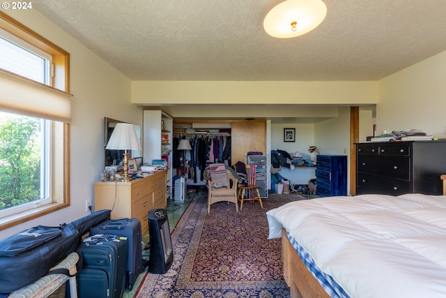 carpeted bedroom with a closet and a textured ceiling