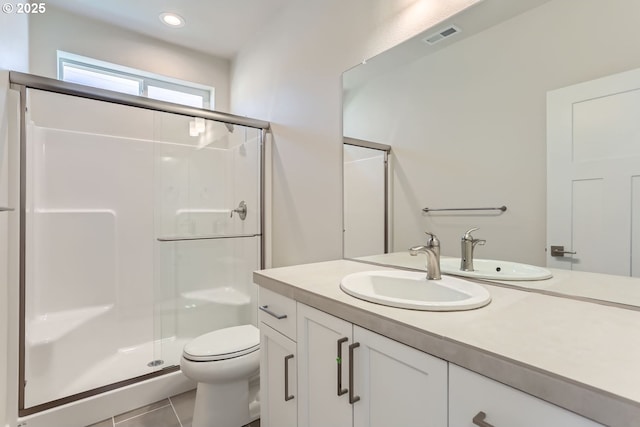 bathroom with vanity, tile patterned flooring, toilet, and walk in shower