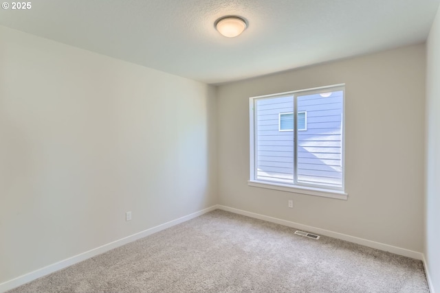 carpeted spare room featuring a textured ceiling