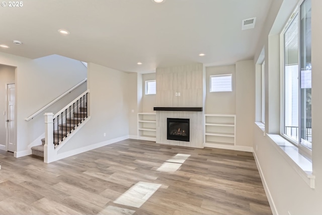 unfurnished living room with light hardwood / wood-style floors and a large fireplace