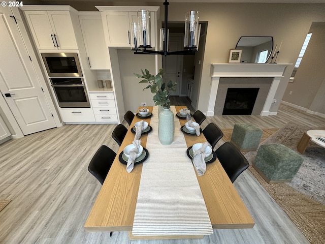 interior space with a chandelier, white cabinets, stainless steel appliances, and light wood-type flooring