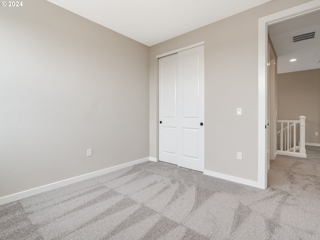 unfurnished bedroom with carpet floors and a closet