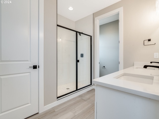 bathroom with vanity, an enclosed shower, and wood-type flooring