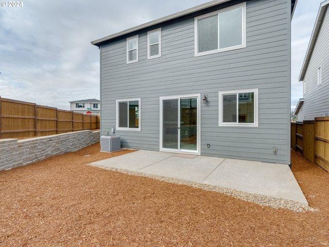 rear view of property with cooling unit and a patio