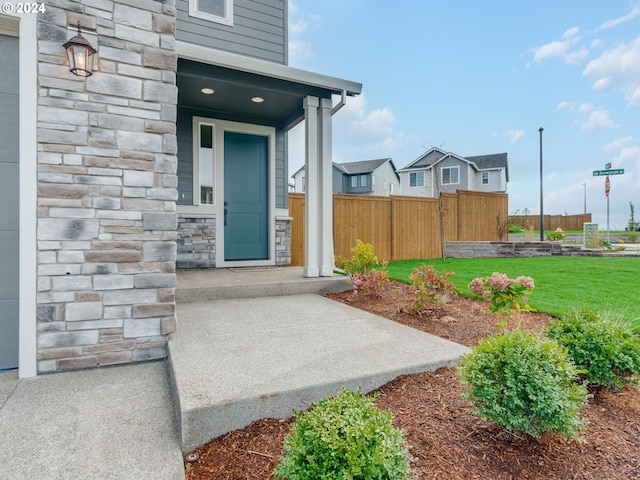 view of exterior entry with a lawn