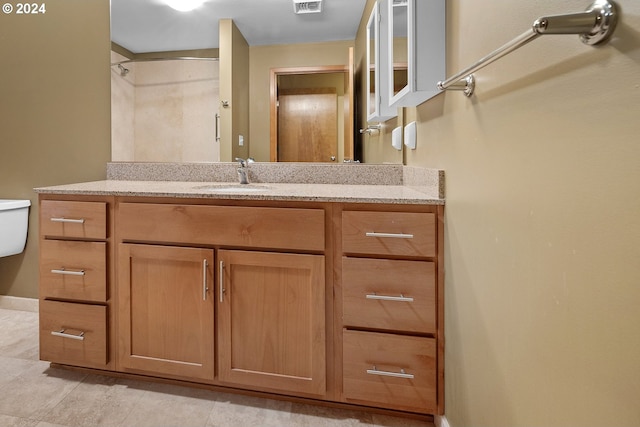 bathroom with tile patterned flooring, vanity, and toilet