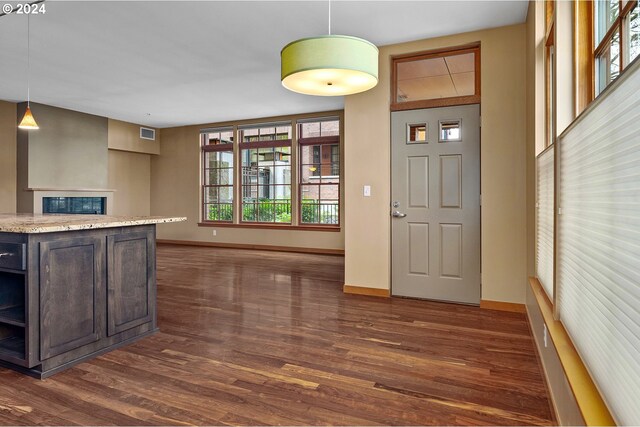 kitchen with dark hardwood / wood-style flooring, dark brown cabinetry, and decorative light fixtures