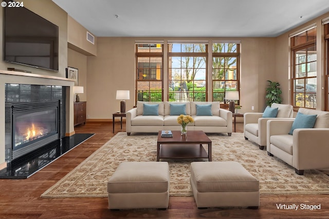 living room with wood-type flooring and a premium fireplace