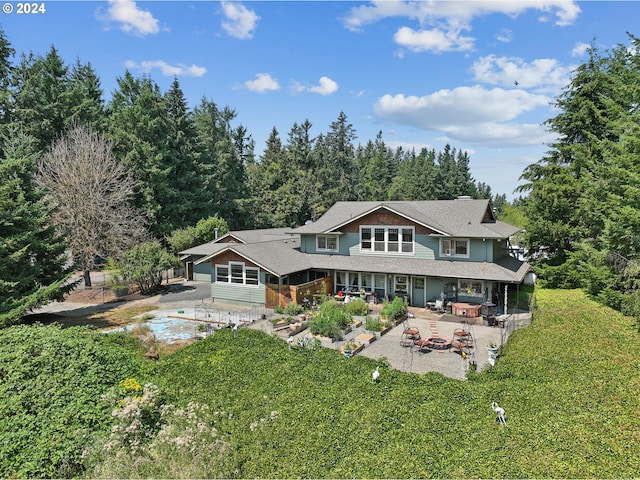 rear view of house with a patio area, cooling unit, and a fire pit