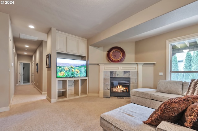 living room featuring light carpet and a tile fireplace