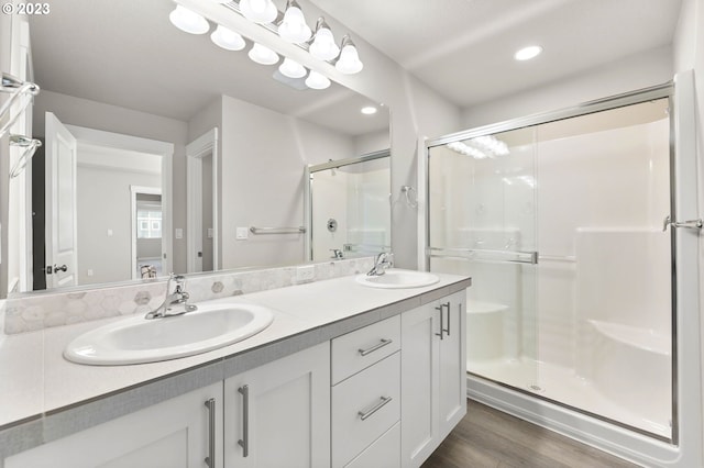 bathroom featuring a shower with door, vanity, and hardwood / wood-style flooring