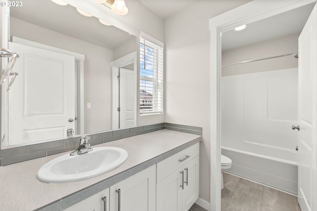 full bathroom featuring vanity, bathtub / shower combination, and toilet