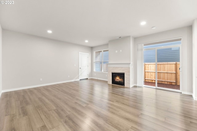 unfurnished living room with a fireplace and light hardwood / wood-style floors